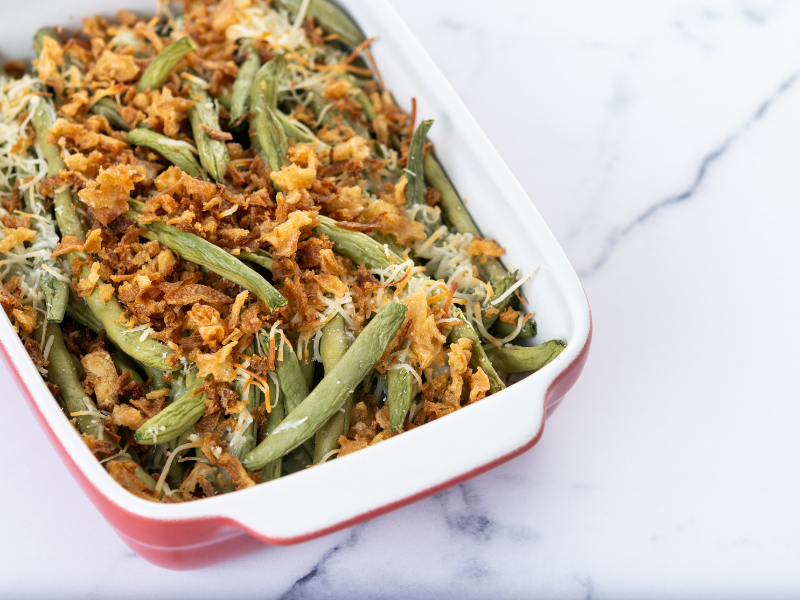 Classic green bean casserole topped with French Fried Onions and cream of mushroom in a casserole dish