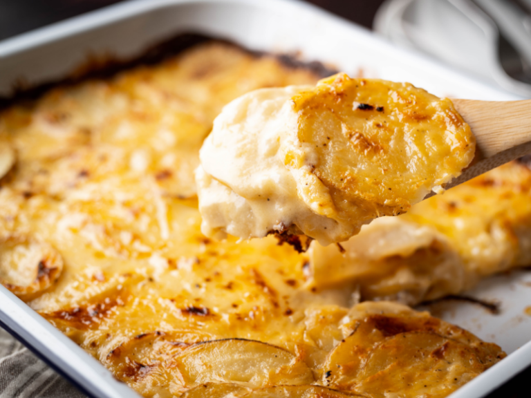 Potatoes au gratin casserole with spoon in casserole dish